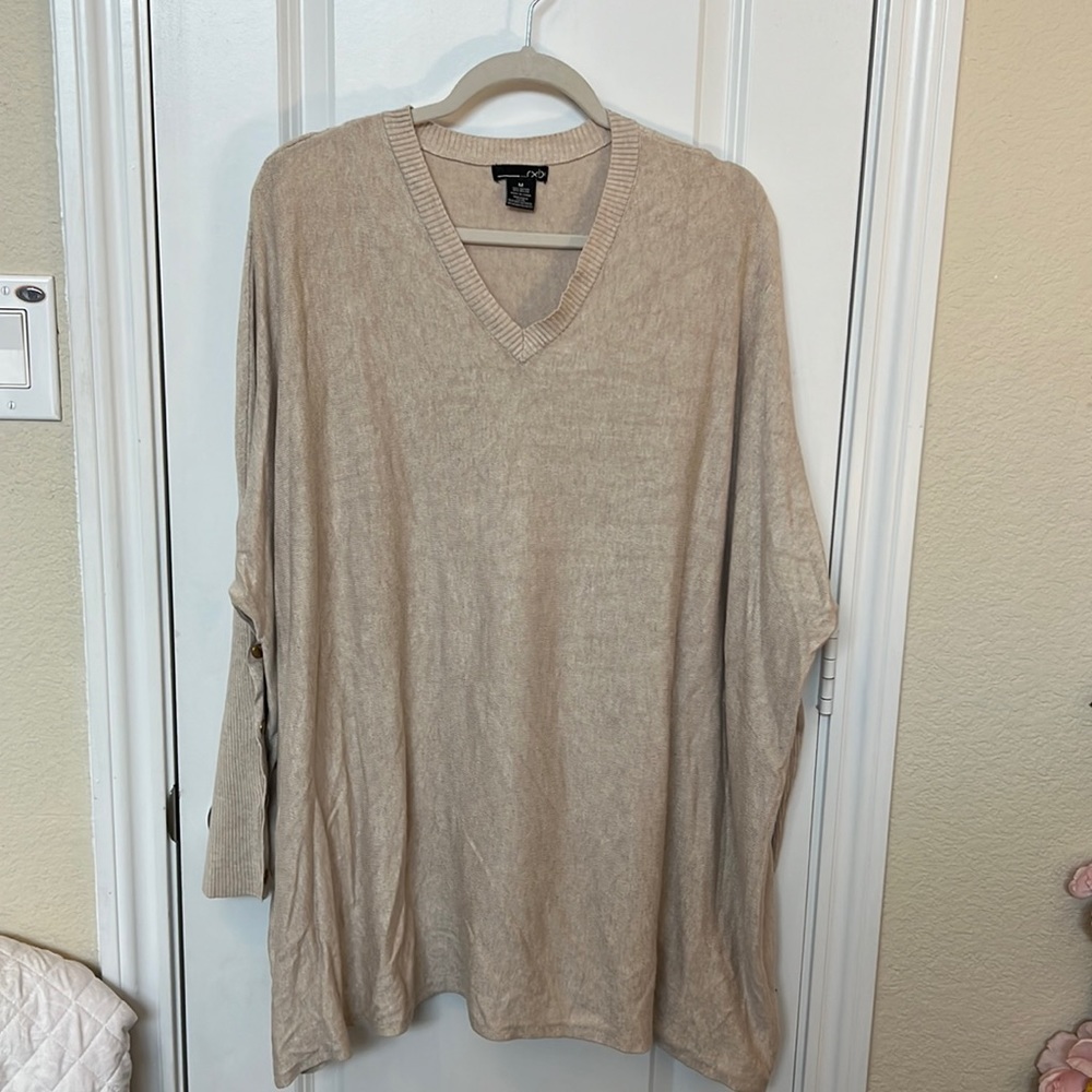 Oversized, lightweight sweater. Gold snap detail on ribbed, fitted sleeves.
